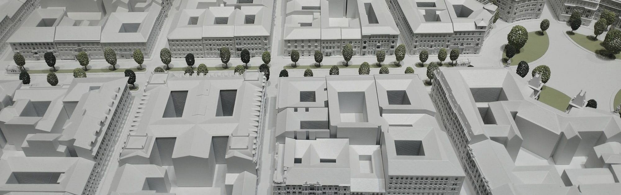 Maqueta blanca de manzanas urbanas con patios y arbolado